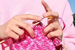 Knitting uses two or more straight needles that carry multiple stitches.